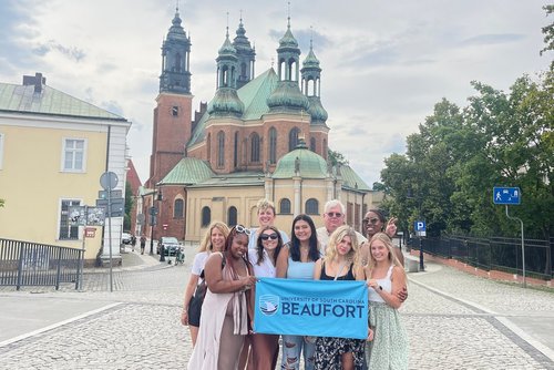 Study abroad students in Poznan holding up banner